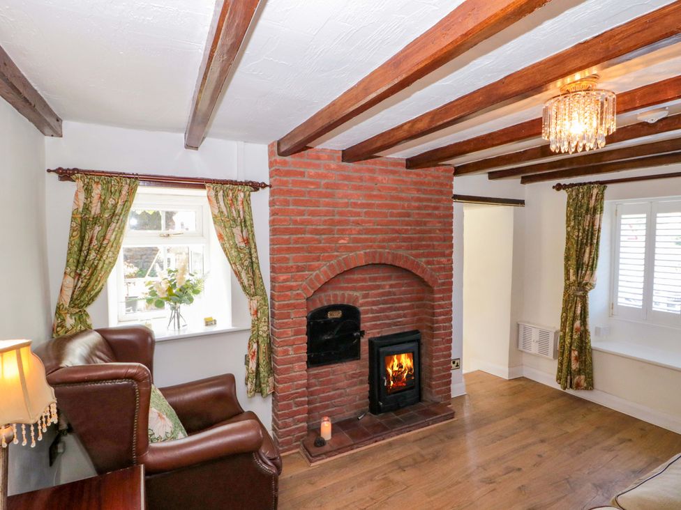 A living room with an armchair and fireplace at Rose Cottage in East Ayton