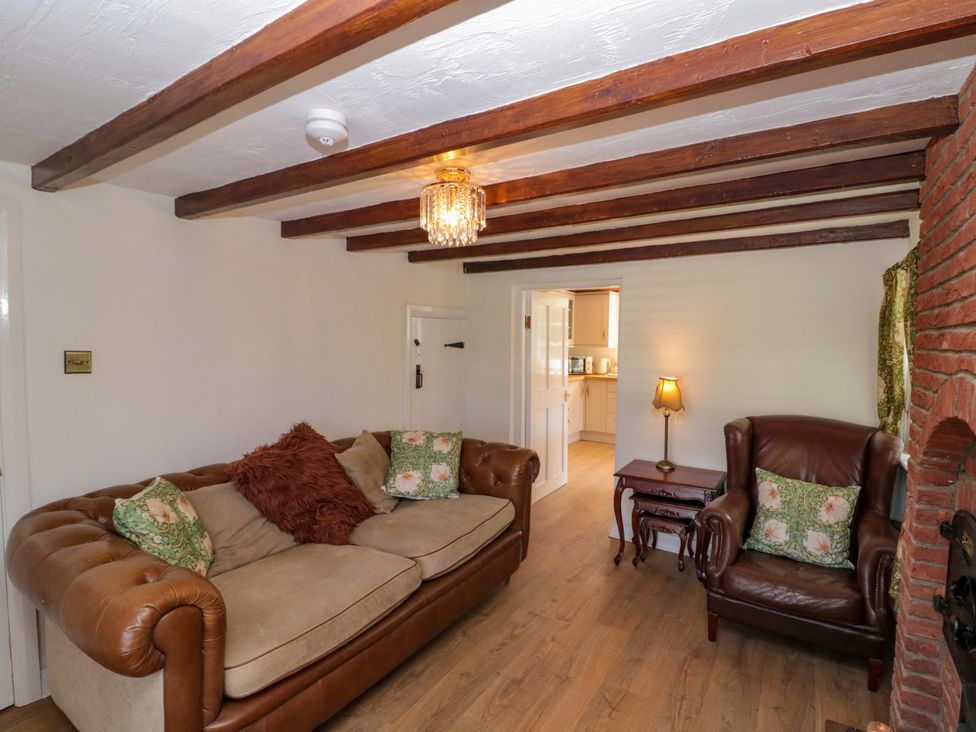 A living room with a sofa and chair at Rose Cottage in East Ayton