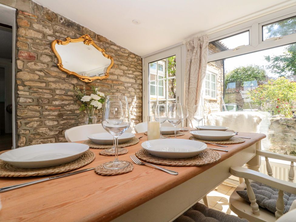 A dining room with a table set for a meal at Rose Cottage in East Ayton