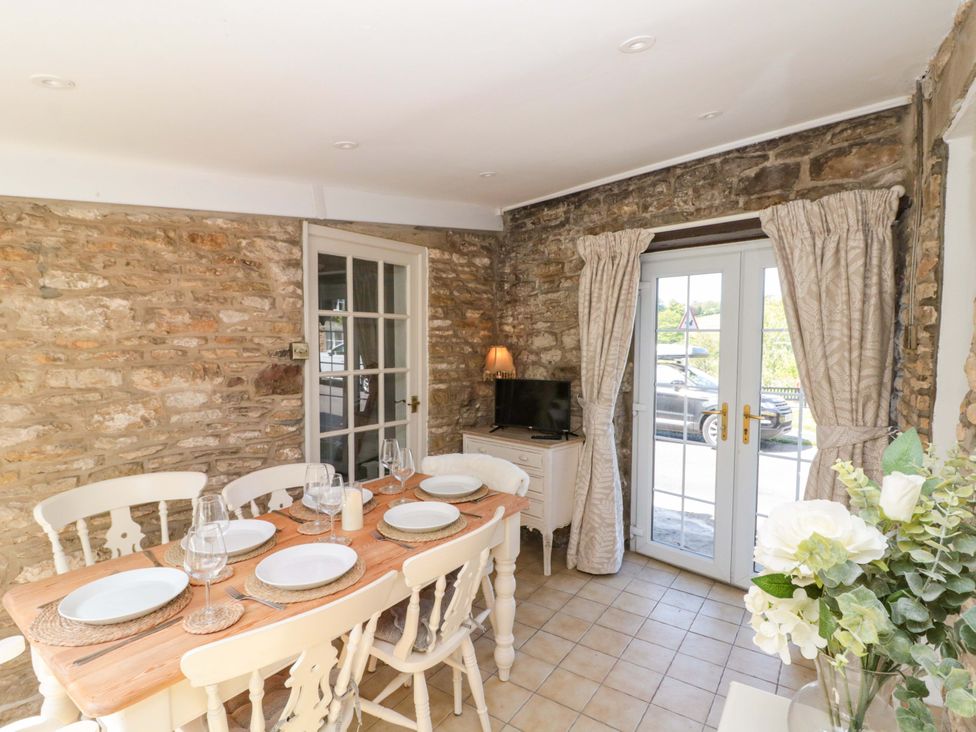 A dining room with a table and chairs at Rose Cottage in East Ayton