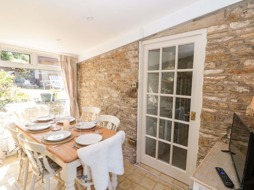 A dining room with a table set for dinner at Rose Cottage in East Ayton
