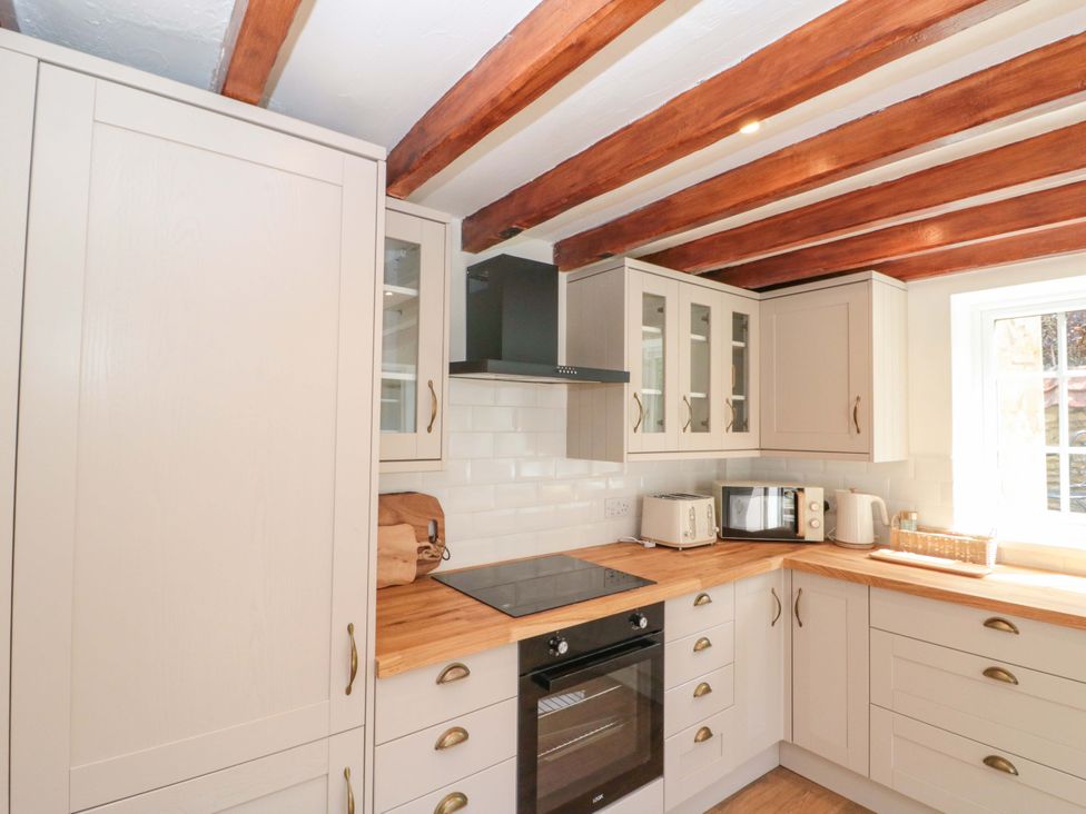 A kitchen with cabinets and appliances at Rose Cottage East Ayton