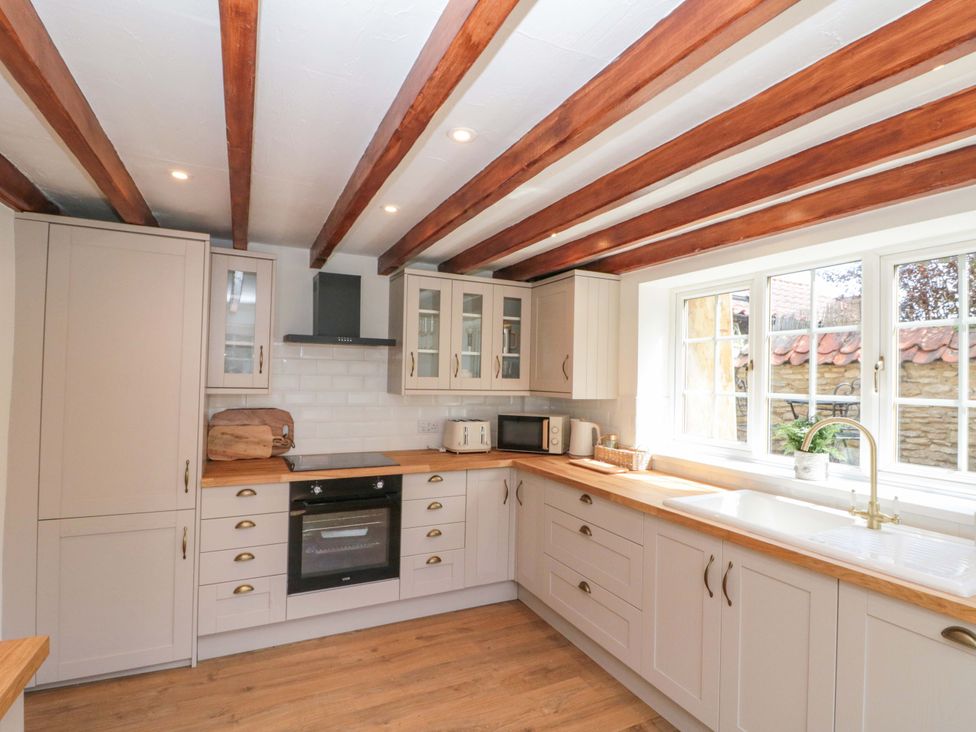 A kitchen with cabinets and countertop at Rose Cottage in East Ayton