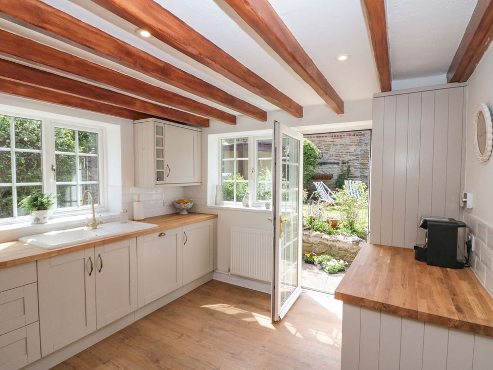 A kitchen with cabinets and a sink at Rose Cottage in East Ayton
