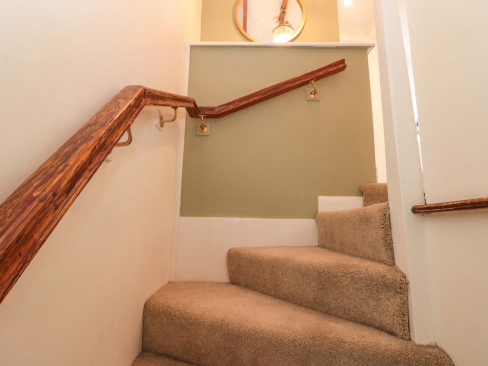 A staircase with a handrail and carpet at Rose Cottage in East Ayton