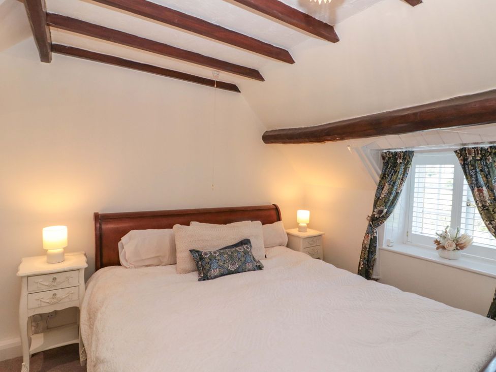 A bedroom with a bed and nightstand at Rose Cottage in East Ayton