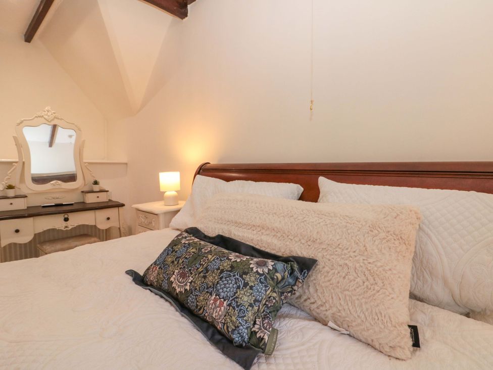 A bedroom with a bed and dresser at Rose Cottage in East Ayton