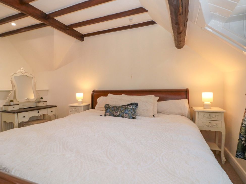 A bedroom with a bed and dresser at Rose Cottage East Ayton