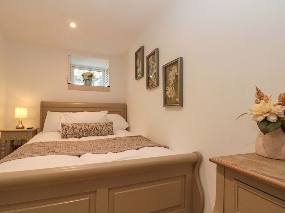 A bedroom with a bed and window at Rose Cottage in East Ayton