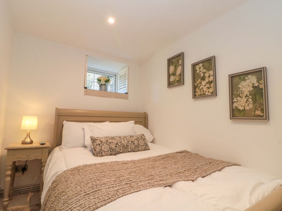 A bedroom with a bed and window at Rose Cottage East Ayton