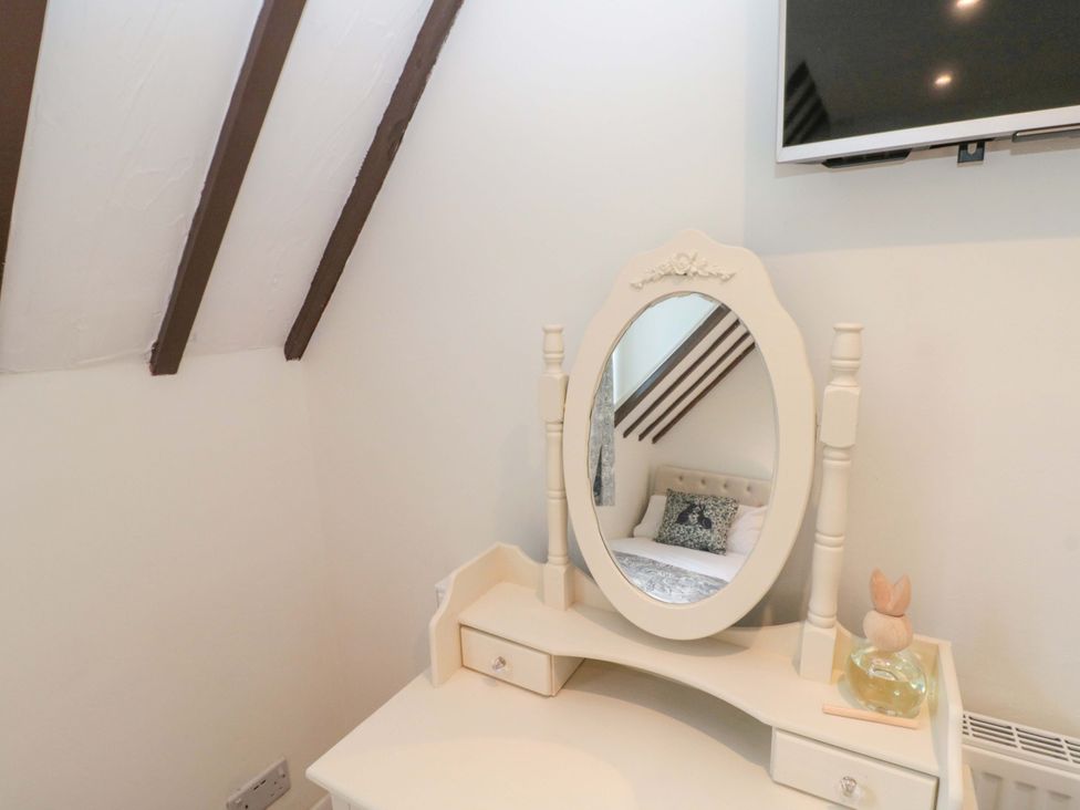 A dressing table with a mirror and a television in the bedroom at Rose Cottage East Ayton