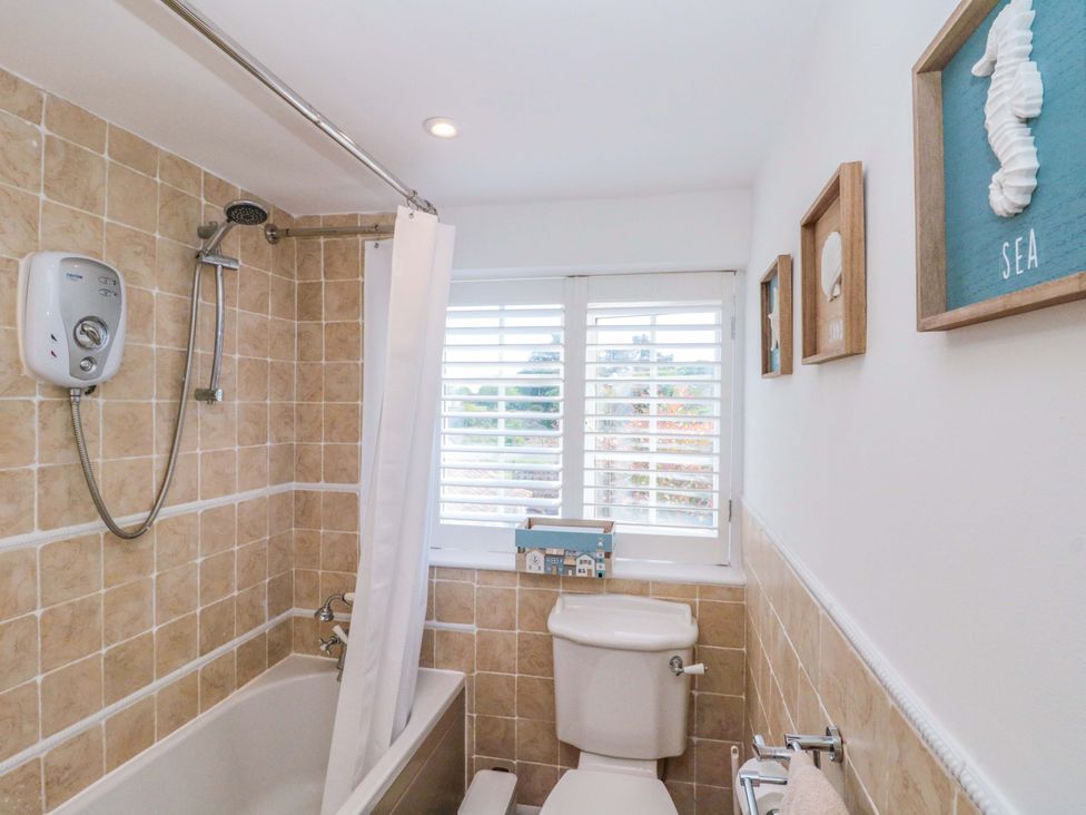 A bathroom featuring a bathtub, toilet, and shower at Rose Cottage in East Ayton