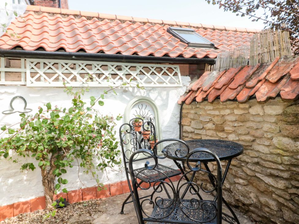 An outdoor area with a table and chairs at Rose Cottage in East Ayton