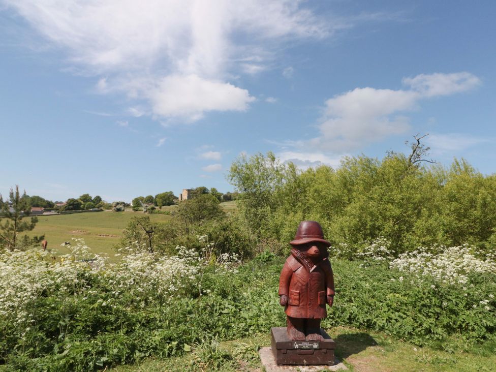 A wooden statue in a field with greenery at Rose Cottage, East Ayton