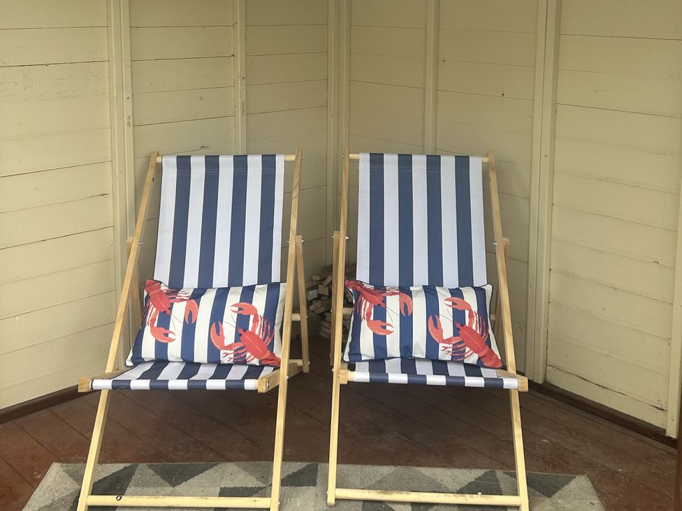 Two deck chairs with cushions in an outdoor seating area at Rose Cottage, East Ayton