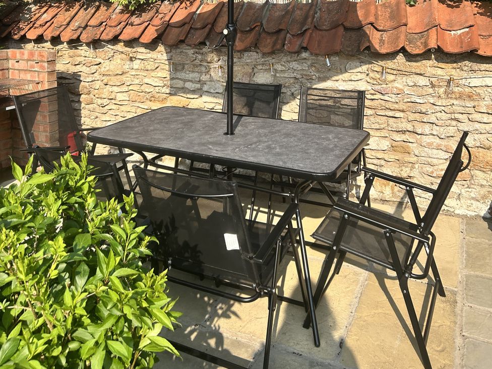 An outdoor dining area with a table and chairs at Rose Cottage in East Ayton