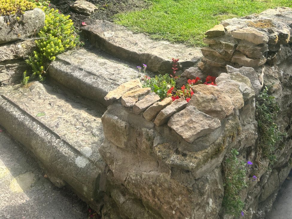 A stone staircase with flowers next to it at Rose Cottage in East Ayton