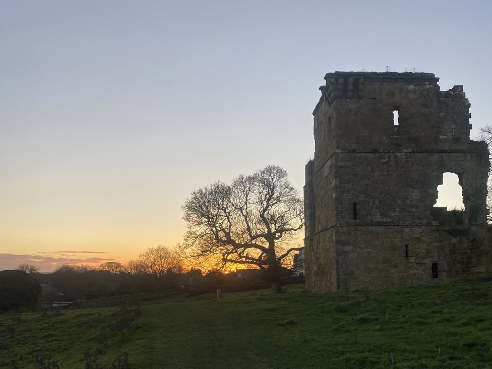 A ruin beside a tree at sunset
