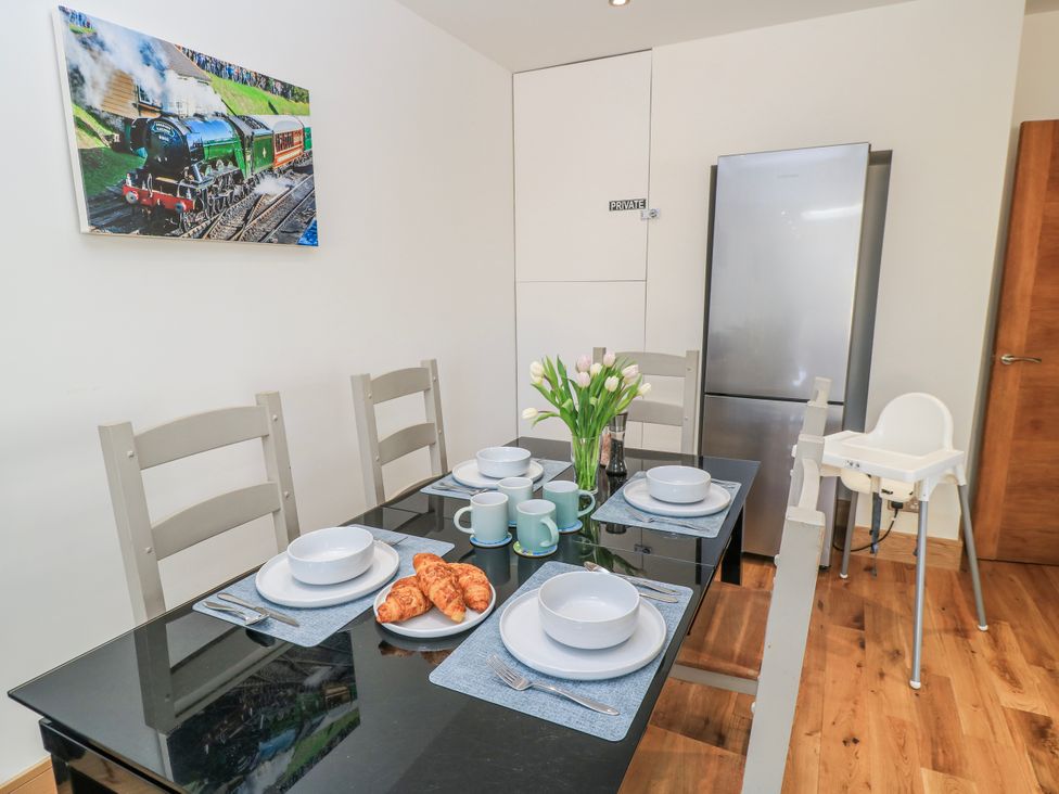 A dining room with a table set with plates and croissants at The Swanage Rail Lookout in Swanage