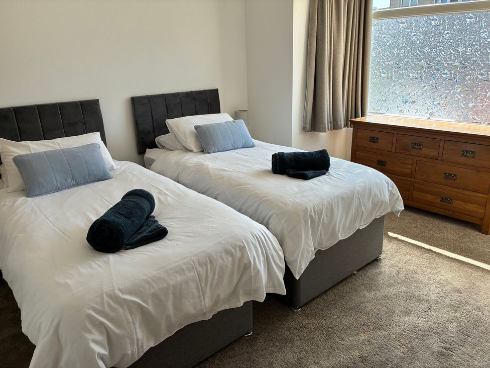A bedroom with two beds and a dresser at The Swanage Rail Lookout in Swanage