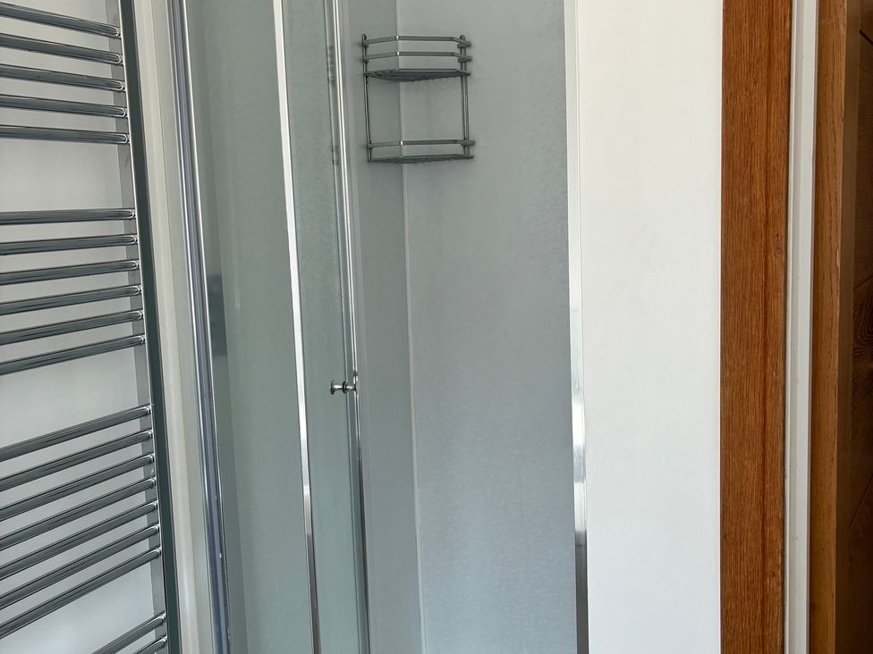 A bathroom with a shower and a towel rail at The Swanage Rail Lookout in Swanage