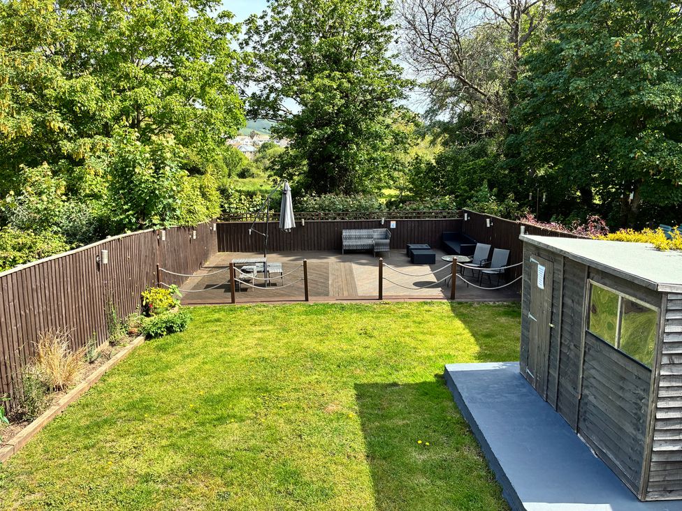 A garden with a wooden deck and outdoor furniture at The Swanage Rail Lookout in Swanage