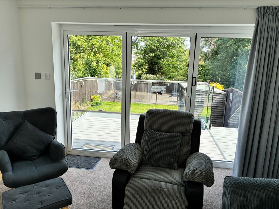 A living room with sliding doors and chairs at The Swanage Rail Lookout in Swanage