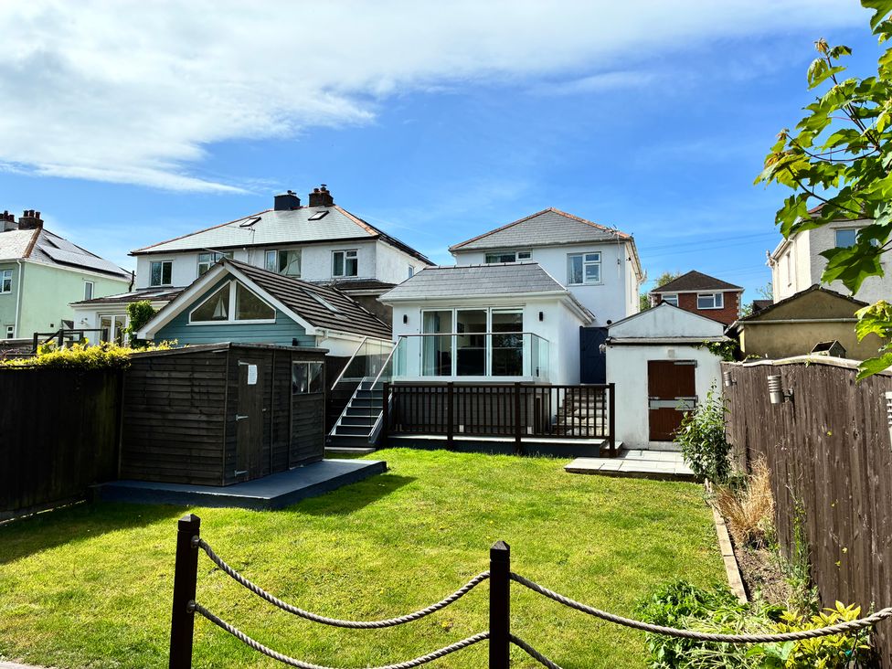 A garden with grass and a wooden shed at The Swanage Rail Lookout in Swanage