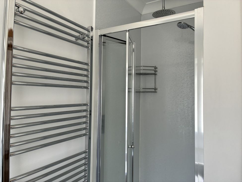 A bathroom with a shower and towel warmer at The Swanage Rail Lookout in Swanage