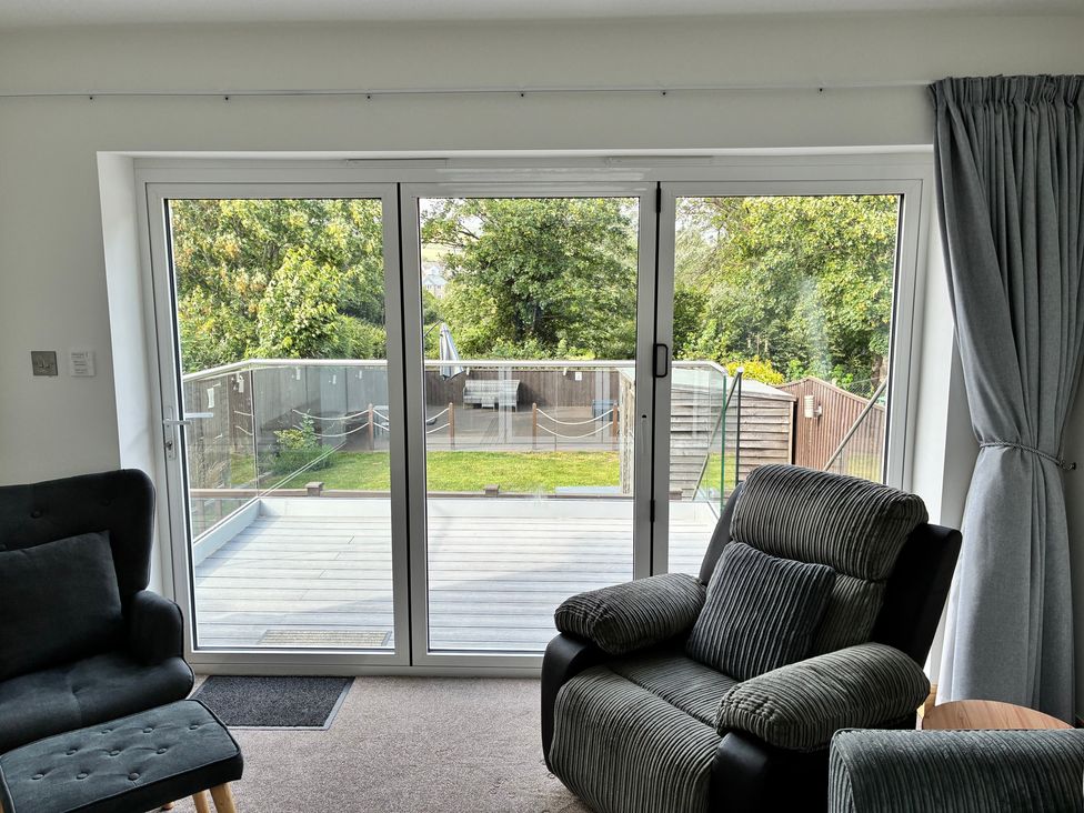 A living room with sliding doors leading to a deck at The Swanage Rail Lookout in Swanage
