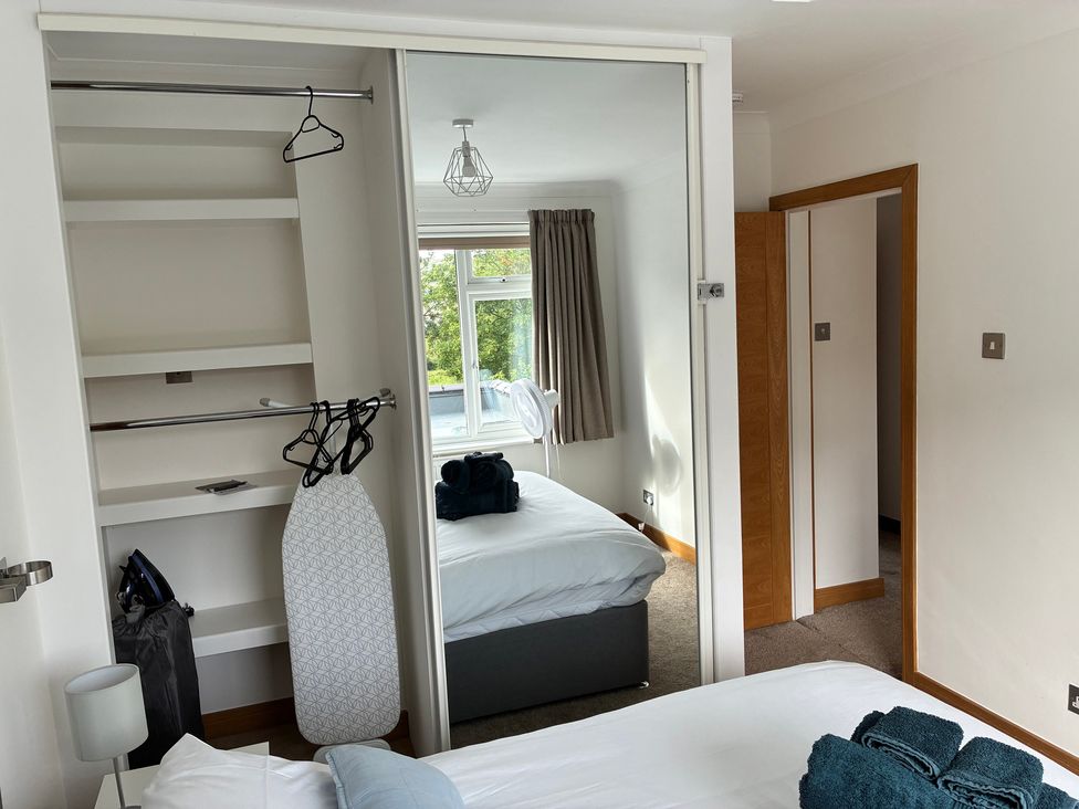 A bedroom with a bed, wardrobe, and window at The Swanage Rail Lookout in Swanage
