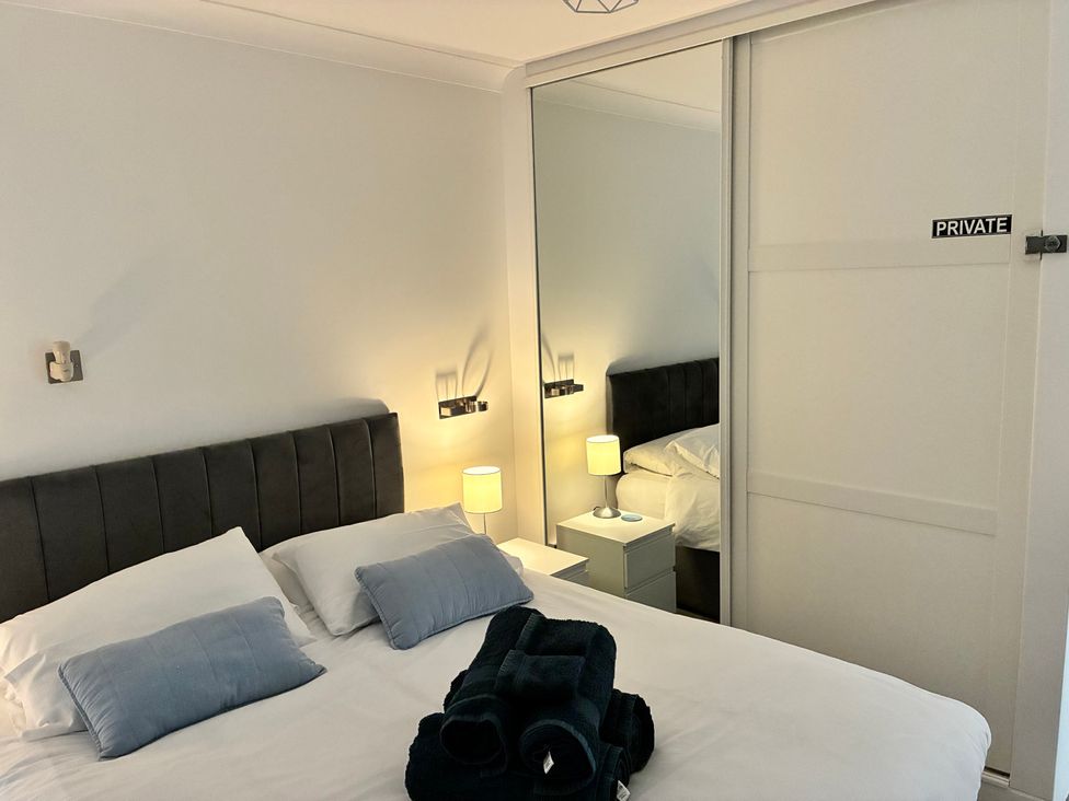 A bedroom with a bed and bedside table at The Swanage Rail Lookout in Swanage
