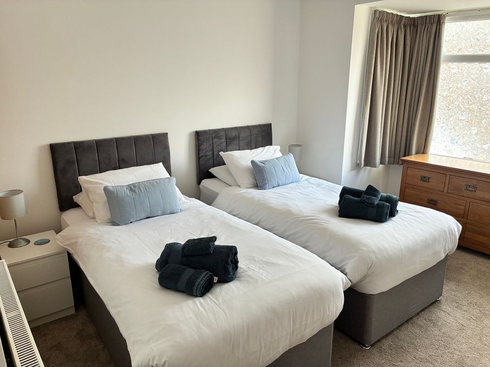 A bedroom with twin beds and a dressing table at The Swanage Rail Lookout in Swanage