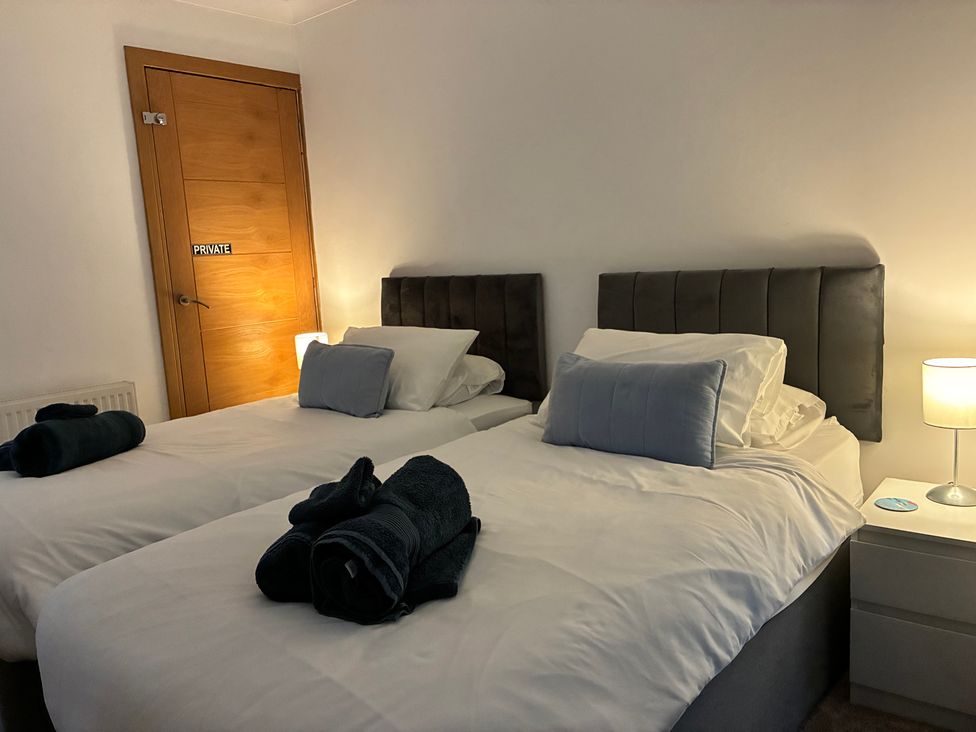 A bedroom with two beds and a lamp at The Swanage Rail Lookout in Swanage