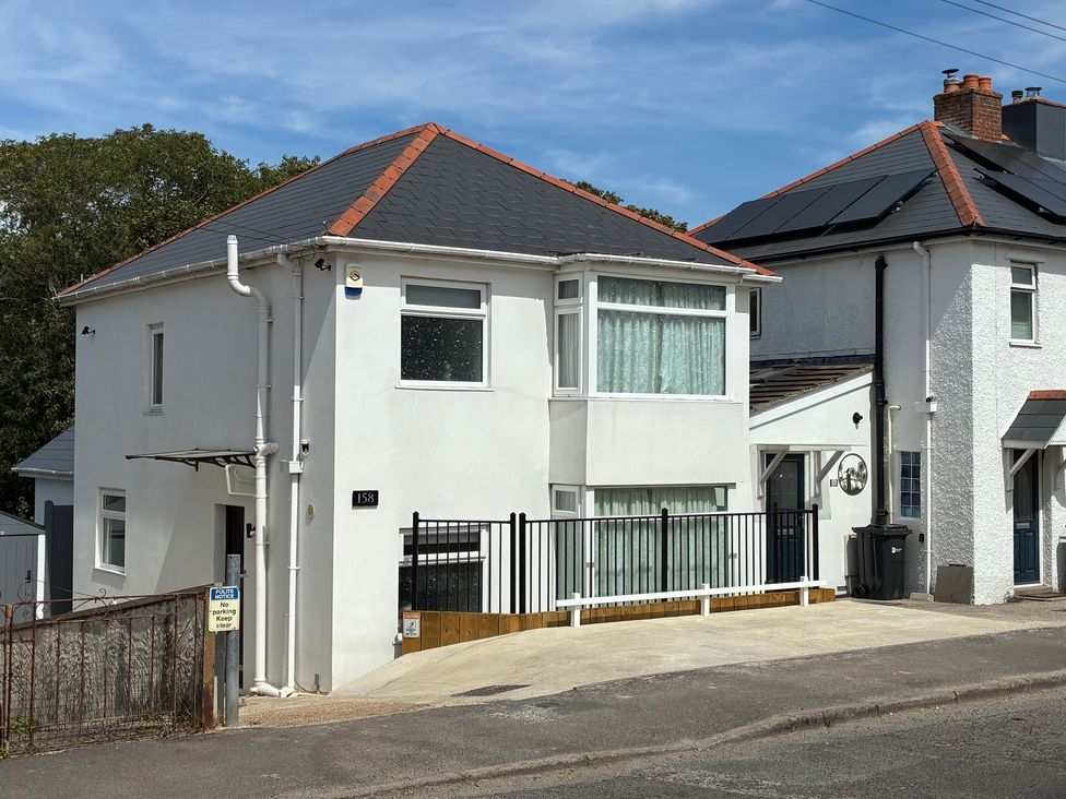 A house with a driveway and a fence at The Swanage Rail Lookout in Swanage