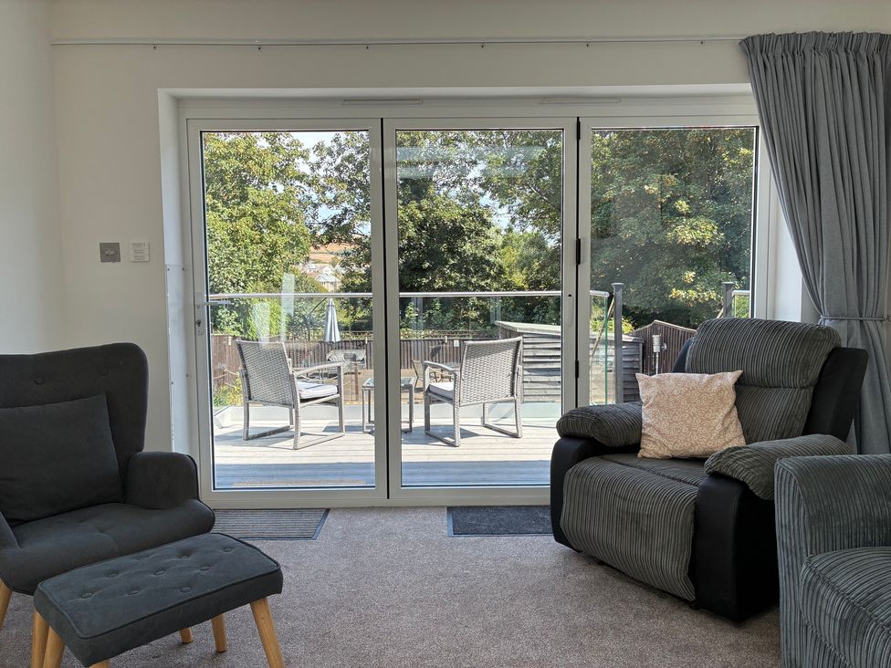 A living room with sliding doors leading to a deck at The Swanage Rail Lookout in Swanage