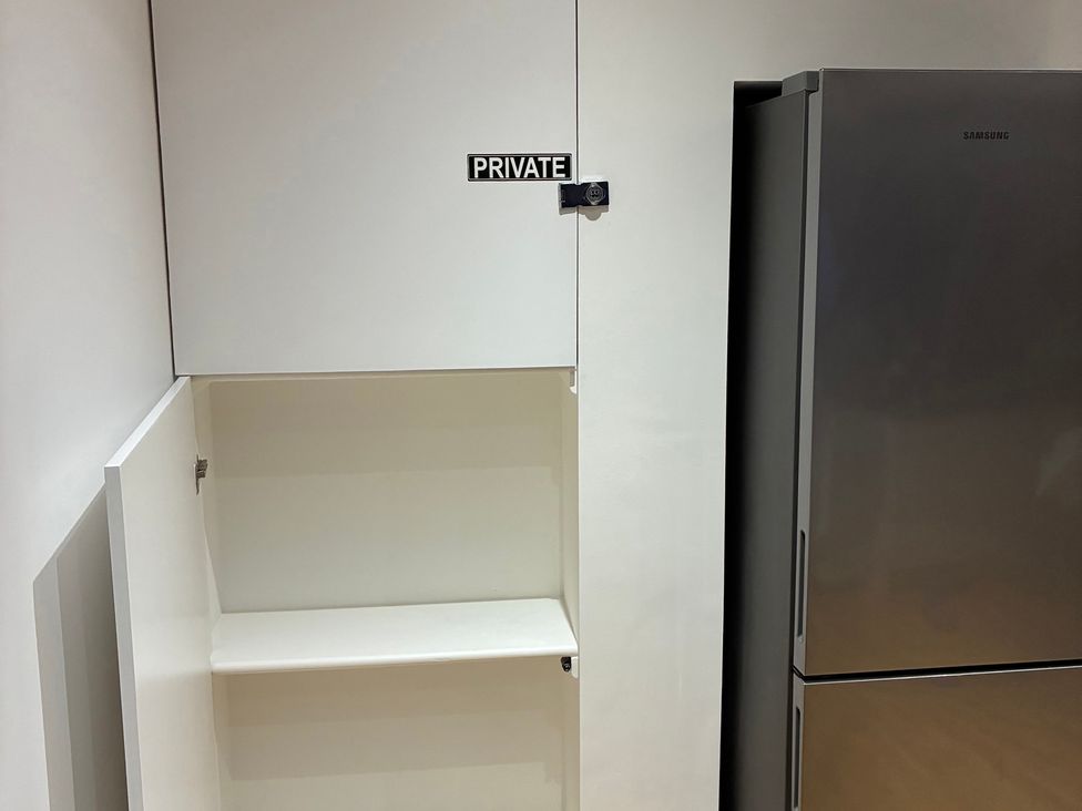 A cabinet and refrigerator in a kitchen at The Swanage Rail Lookout in Swanage
