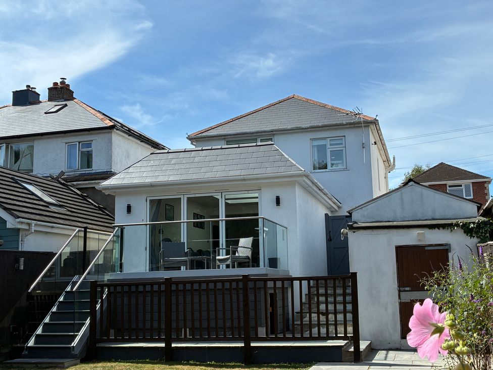 An outdoor view of a house with a balcony and garden at The Swanage Rail Lookout in Swanage