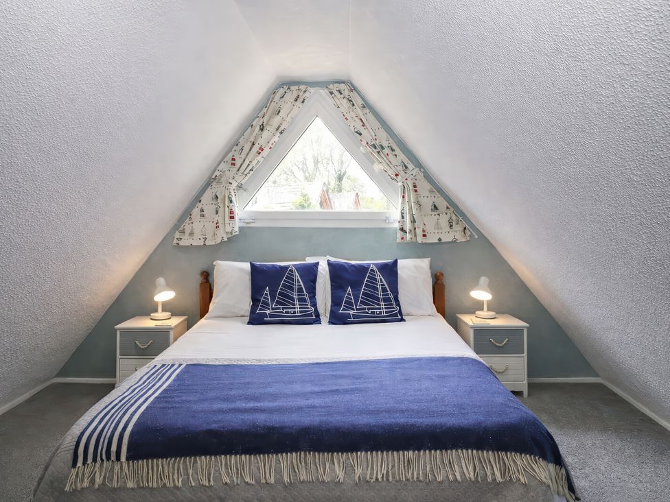 A bedroom with a bed and bedside tables at Chalet 58 - The Beach House Kingsdown