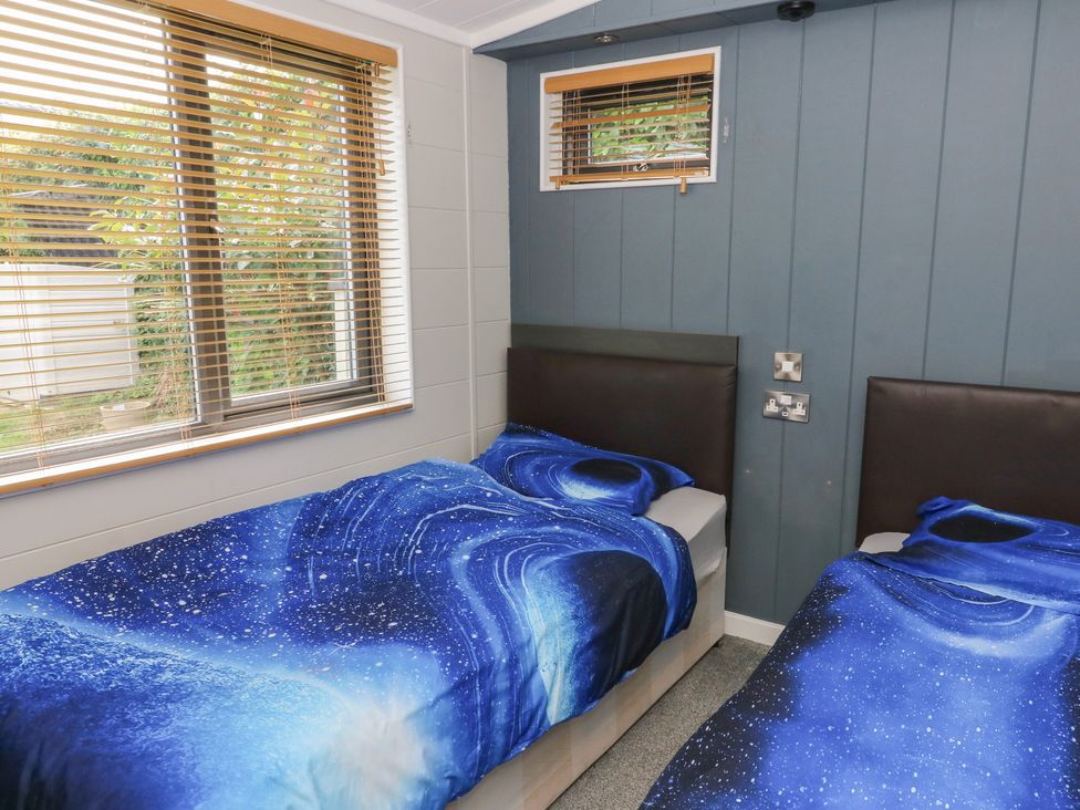 A bedroom with two beds and blankets at Coogee View in Maenygroes near New Quay