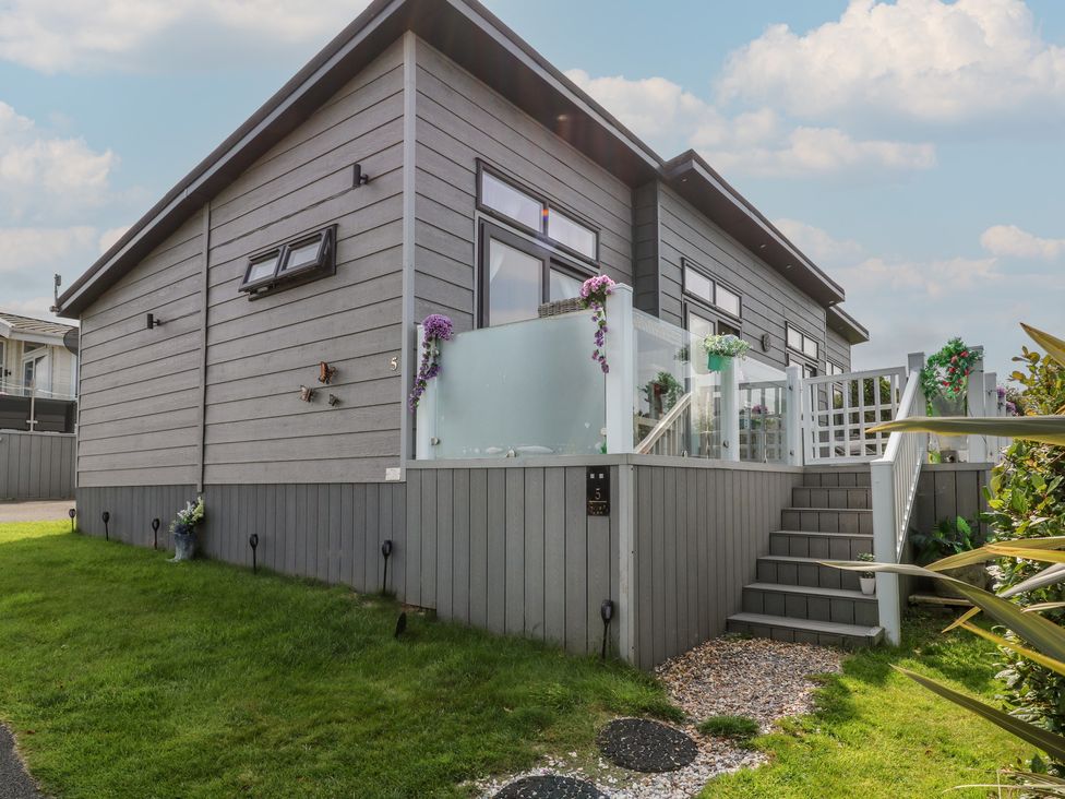 A house with a deck and steps at Coogee View in Maenygroes near New Quay