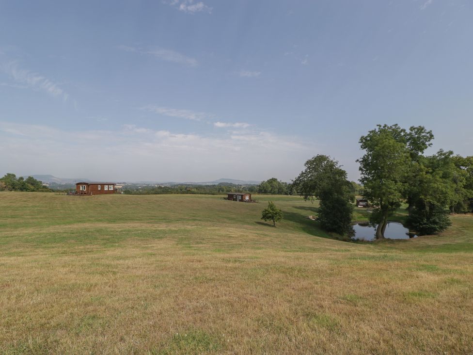 An outdoor view of cabins and a pond at Hollie in Raglan