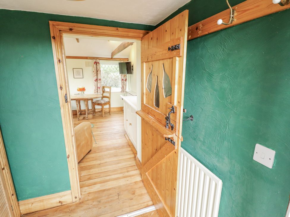 An entrance hall with a wooden door and a view of the dining area at Pendockie in Boston