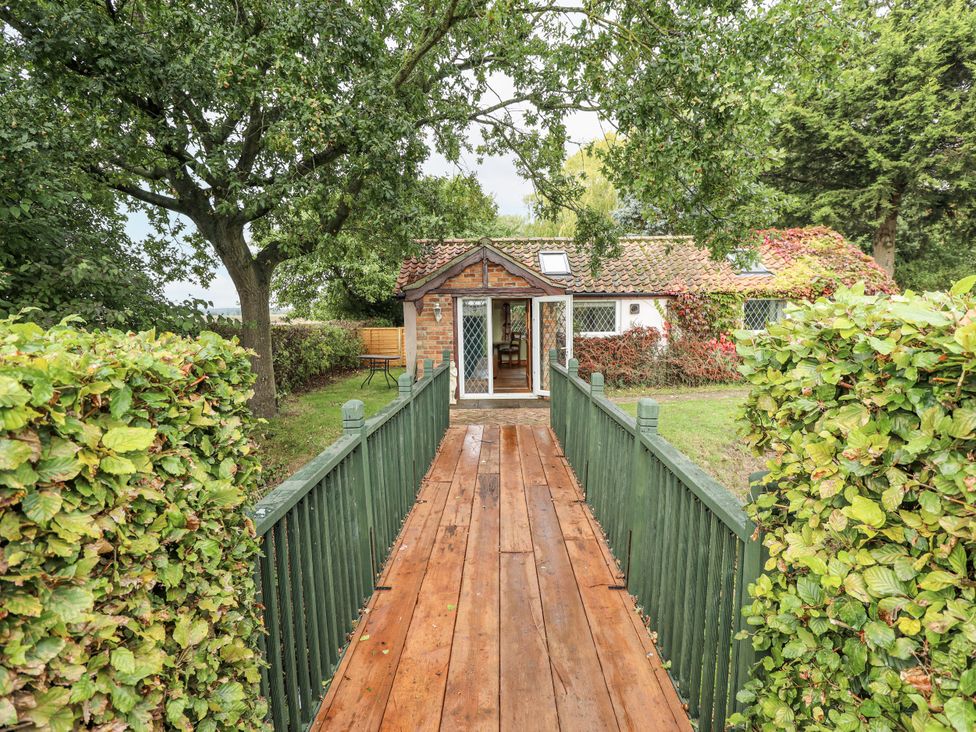 A wooden pathway leading to a house surrounded by greenery at Pendockie in Boston