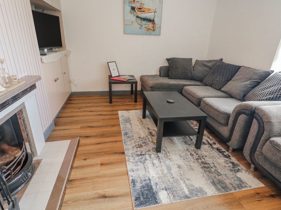 A living room with a sofa, coffee table, television, and fireplace at The Island's View in Gortahork, County Donegal