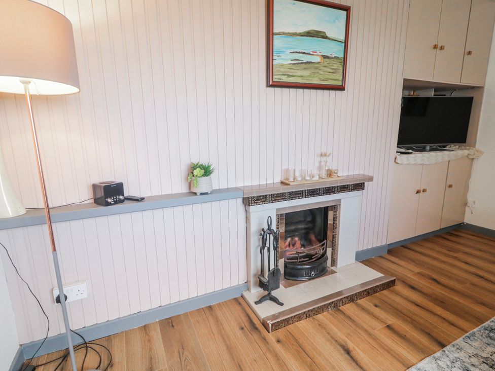 A living room with a fireplace and television at The Island's View in Gortahork, County Donegal