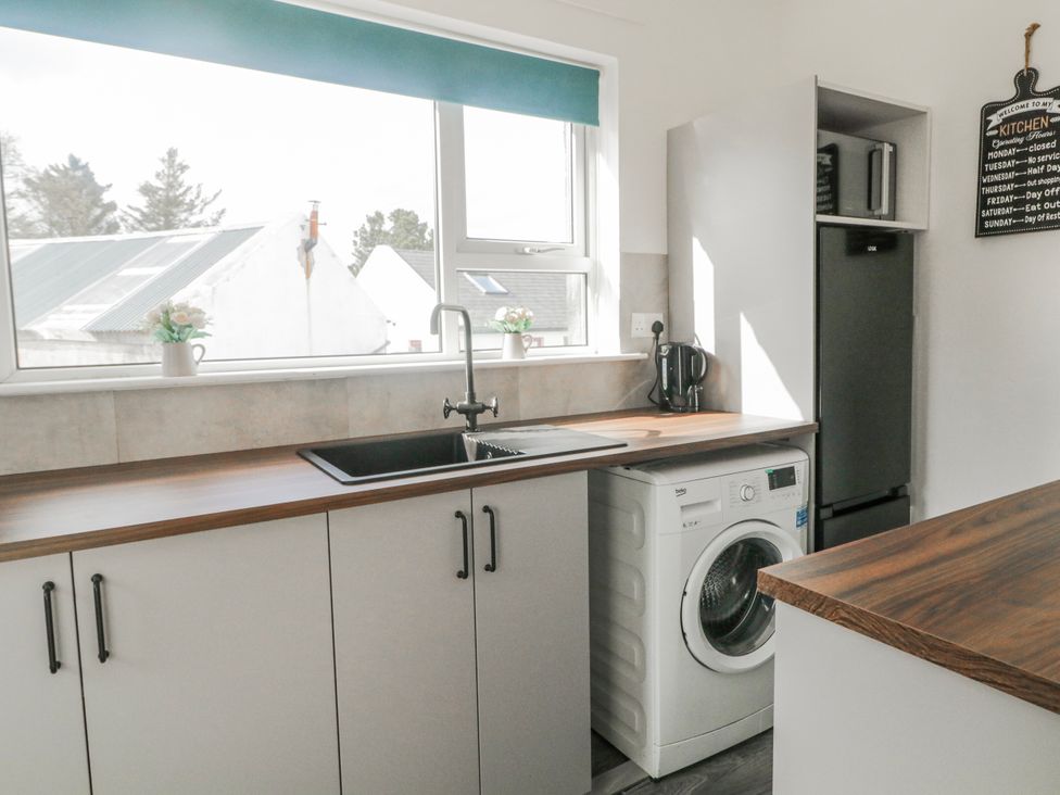 A kitchen with a sink and washing machine at The Island's View in Gortahork, County Donegal