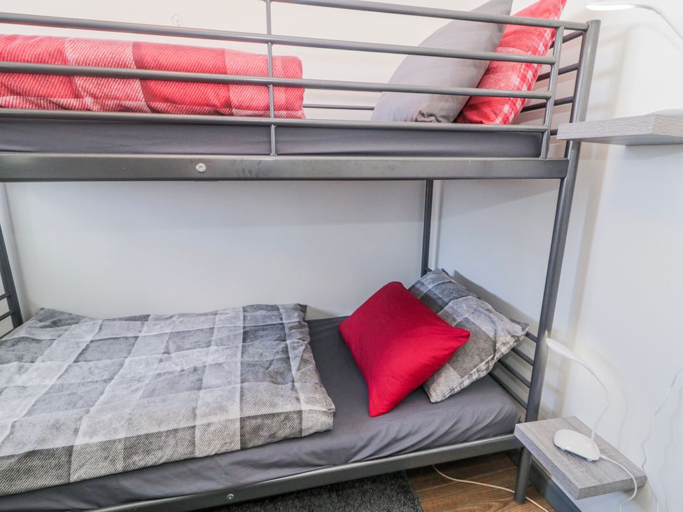 A bunk bed with gray bedding and red pillows at The Island's View in Gortahork, County Donegal