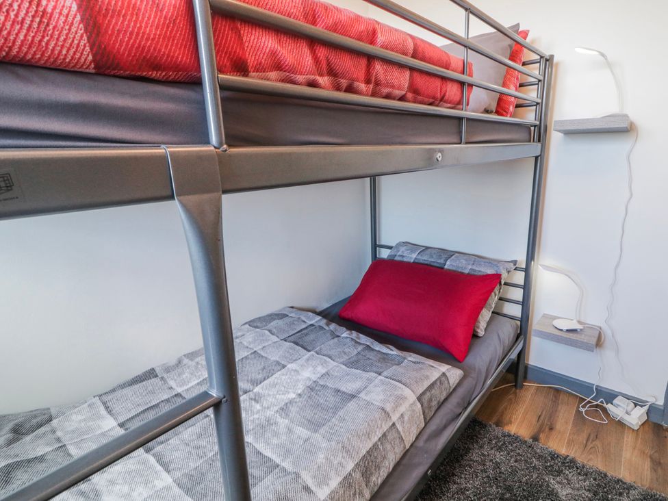 A bunk bed with red and grey bedding at The Island's View in Gortahork, County Donegal