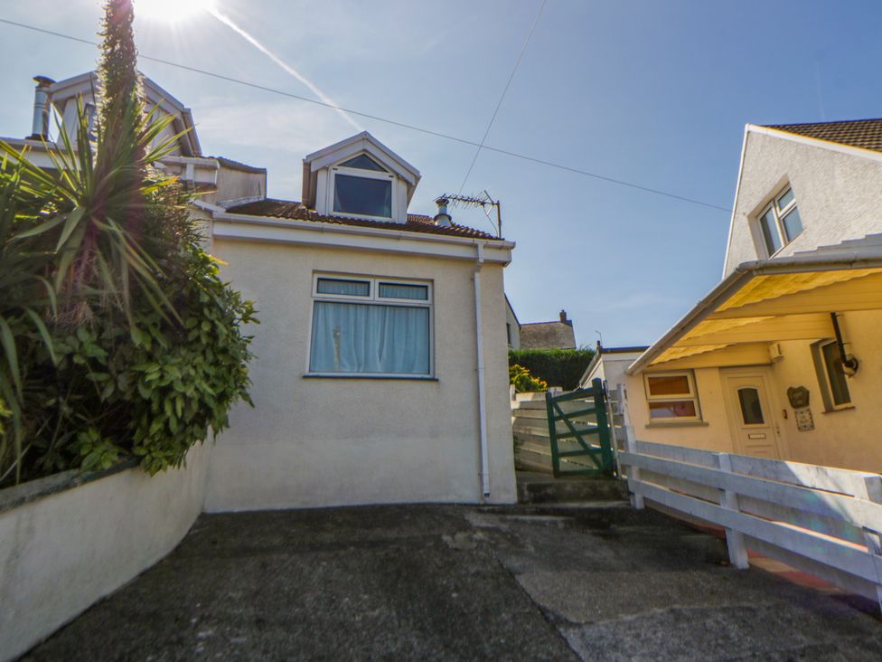 An outdoor view of a house with a driveway and plants at Harbour High Annex in Fishguard
